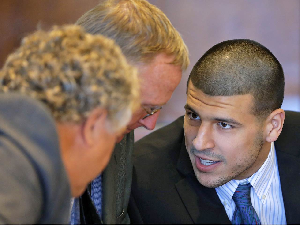 Aaron Hernandez, formerly of the New England Patriots, talks to defense attorneys Michael Fee, left, and Charles Rankin during a court appearance in Fall ...
