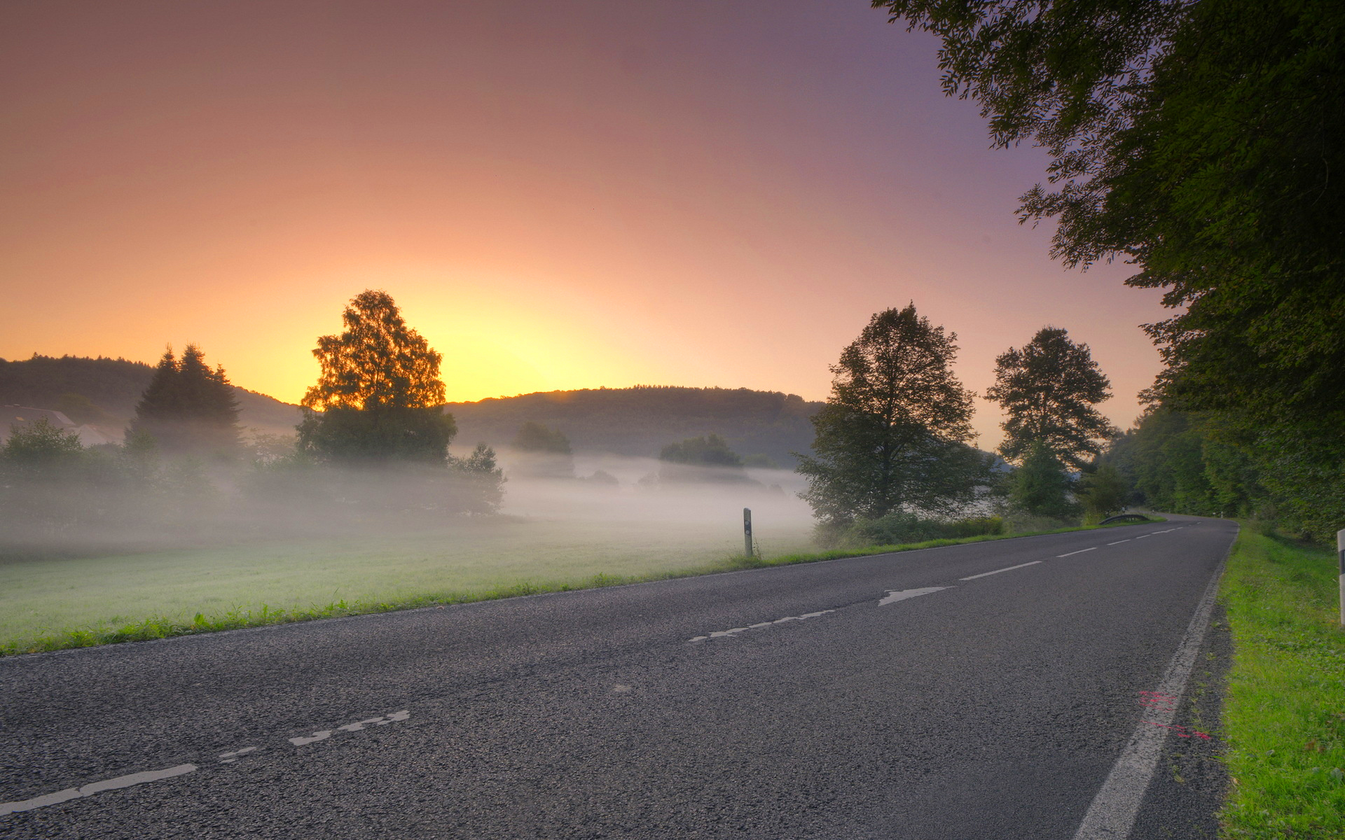 Sunrise road morning mist