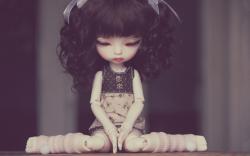 Sad doll sitting