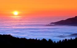 Sunset fog over sea mountains